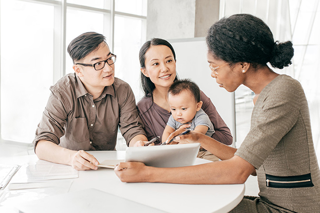 A family sits at a table with a counselor.
